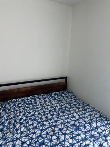 a bedroom with a bed with a blue and white comforter at Goldwin's Place in Toronto