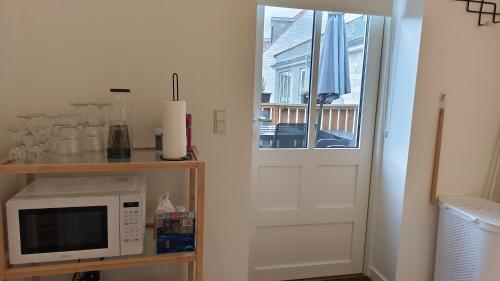 a kitchen with a white microwave and a window at Cozy Apartment Stevns in Store Heddinge