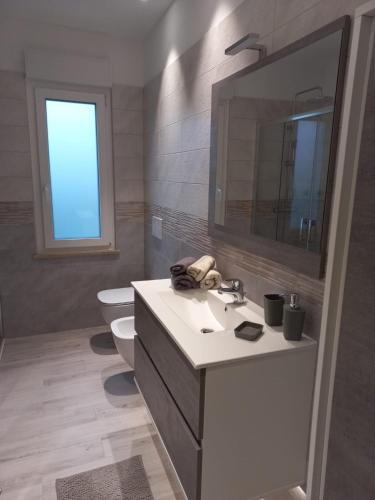a bathroom with a sink and a toilet and a mirror at Casa Lilly 