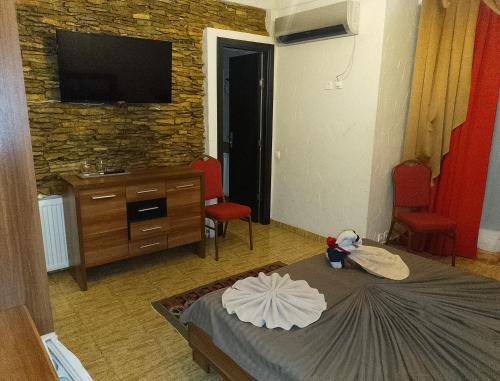 a room with a bed with a tv on the wall at Samaya in Eforie Nord