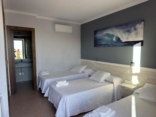 a hotel room with two beds and a window at La Brisa de Tarik Rooms in Tarifa