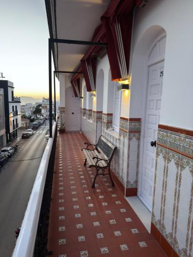 a bench sitting on the balcony of a building at La Brisa de Tarik Rooms in Tarifa