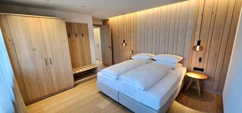 リスコネにあるMountain Residence CLARAの木製キャビネット付きの客室で、白い大型ベッド1台が備わります。