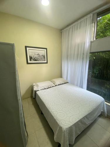 a small bedroom with a bed and a window at Pousada Girassol in Rio de Janeiro