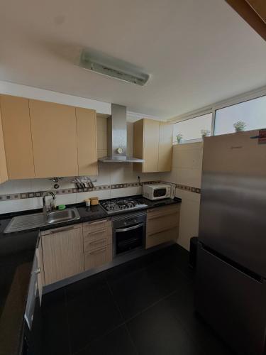 a kitchen with a stove and a sink and a refrigerator at Urban Oasis in Mealhada