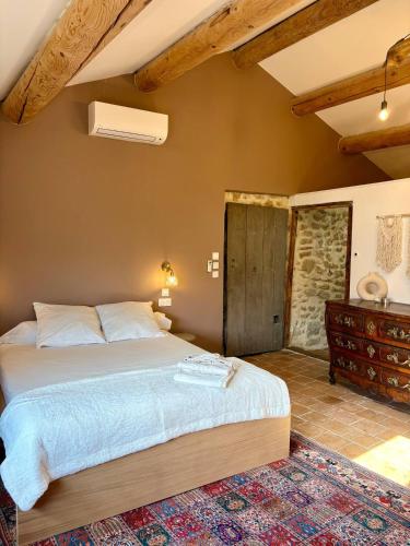 une chambre avec un grand lit dans une pièce dans l'établissement Charming Provencal Retreat with a Lush Private Courtyard, à Rochegude