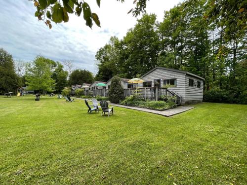 una piccola casa in un cortile con un prato di Cedar Garden Cottages a Wiarton