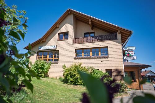 a building with a balcony on the side of it at Mettenberger Hof - Pension in Grafenhausen