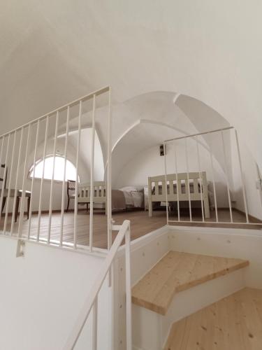 a white room with a staircase and a bedroom at CALEO Guest House in Taurisano