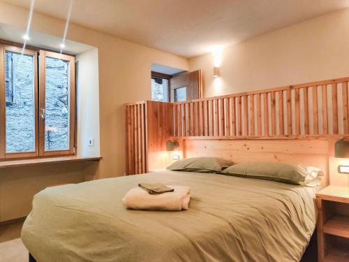 a bedroom with a large bed with a wooden headboard at Ai Parlenti 23 - day&night in Tirano