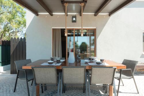 a dining room with a wooden table and chairs at Casa Do Vale - Algarve in Vargem da Mão