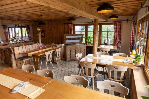 a dining room with wooden tables and chairs at Mettenberger Hof - Pension in Grafenhausen