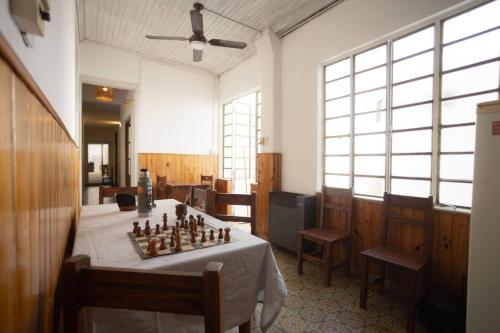 a room with a chess board on a table with chairs at Coliving en Junin Habitacion Simple en Hostel in Junín