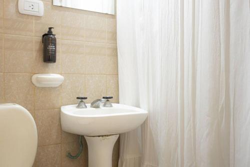 a bathroom with a sink and a shower curtain at Coliving en Junin Habitacion Simple en Hostel in Junín