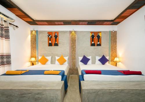 a bedroom with two beds with colorful pillows at Mandavilla Airport Transit Hotel in Katunayake
