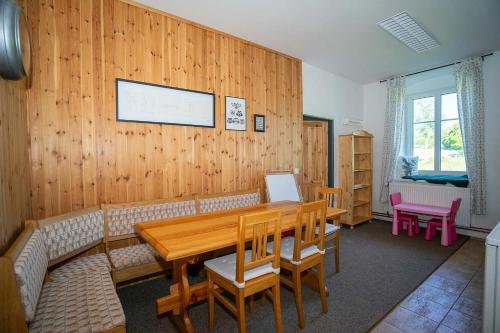 a dining room with a wooden wall with a table and chairs at Hájenka Čenkovice in Čenkovice