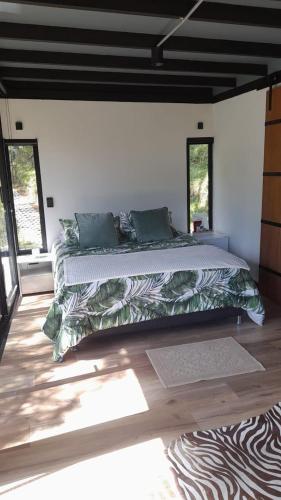 a bedroom with a large bed in a room with windows at 5 Continentes in Guarne