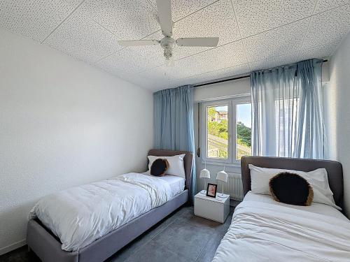 a bedroom with two beds and a window at Riviera House Montreux, un lieu magique ! in Montreux