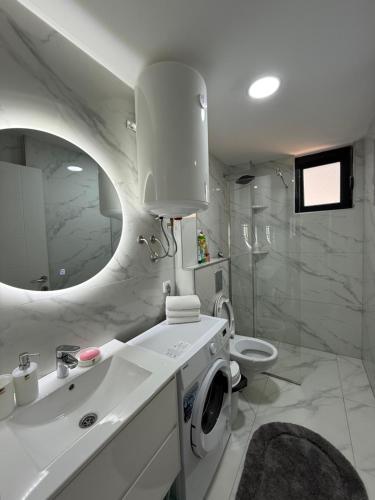 a bathroom with a sink and a washing machine at FB Apartments in Ulcinj