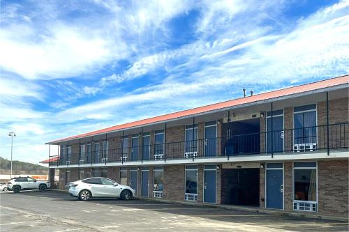 a building with two cars parked in a parking lot at Regal Inn Guntersville By OYO Hwy 431 in Guntersville