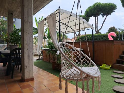 a swinging chair on a patio with a table at Sakura B&B Franciacorta in Cologne