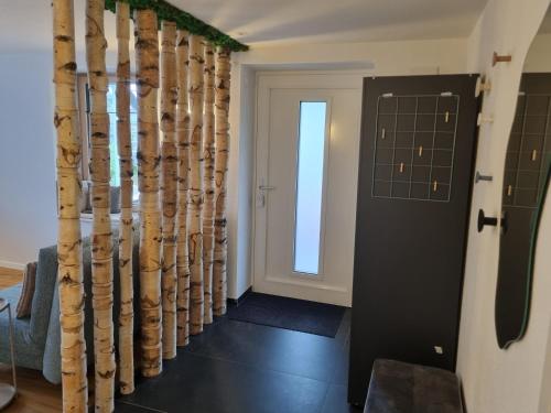 a hallway with a door and a room with a wall of logs at Hideaway Eyb in Ansbach