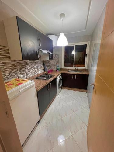 a kitchen with a sink and a dishwasher at Appartement Cosy & Calme avec Piscine, Tamaris Dar Bouazza in Tamaris