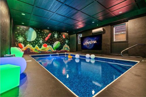 een zwembad in een hotelkamer met een muurschildering bij Indoor Pool - Epic Game Room - MiniGolf - 24 Guests - 8 Bedrooms in Sevierville