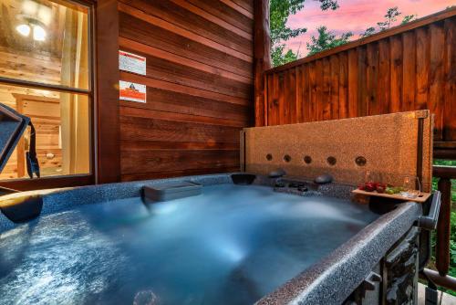 een hot tub in een kamer met een houten muur bij Indoor Pool - Epic Game Room - MiniGolf - 24 Guests - 8 Bedrooms in Sevierville