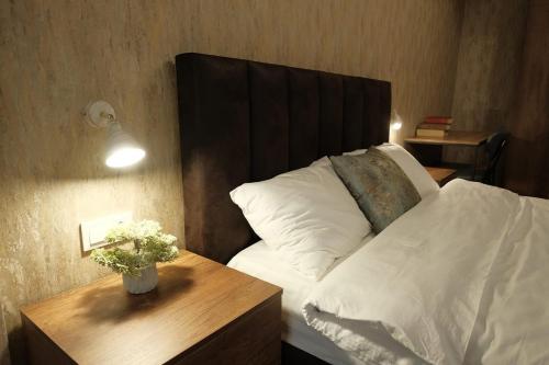 a bedroom with a bed with a wooden head board at Hotel Saguramo Bliss in Saguramo
