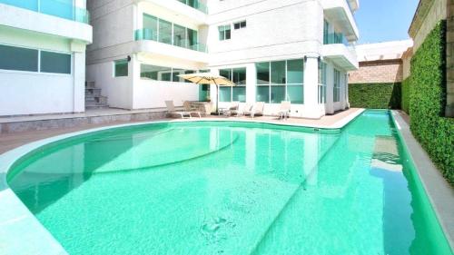 ein Schwimmbad vor einem Gebäude in der Unterkunft Puebla Vista Malinche in Lomas de Angelopolis