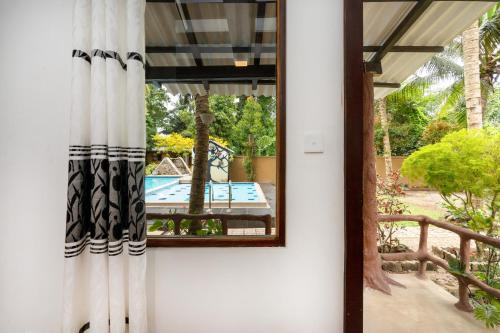 a mirror on the wall of a house with a pool at Mandavilla Airport Transit Hotel in Katunayake