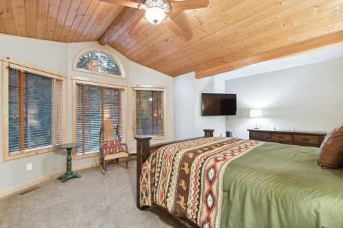 a bedroom with a bed and a flat screen tv at Whispering Pines in Whitefish