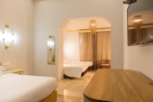 a hotel room with two beds and a table at Hotel Caribe by Faranda Grand, a member of Radisson Individuals in Cartagena de Indias