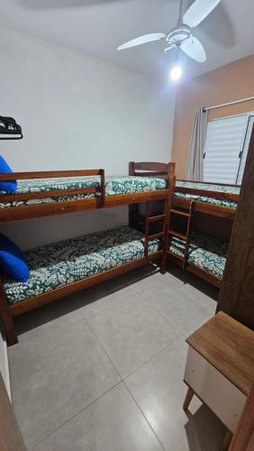 a room with three bunk beds and a ceiling at Apto 2 quartos a 50 metros do Perequê in Ubatuba