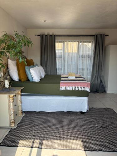 a large bed in a room with a window at KwaSihle Guesthouse in Dobsonville