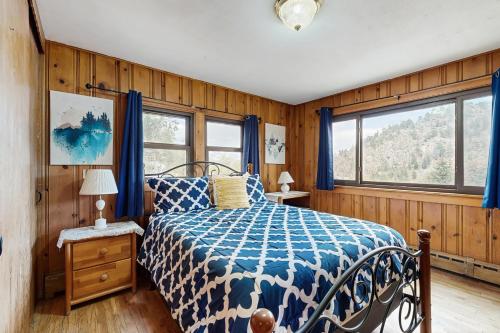 een slaapkamer met een bed met een blauw en wit dekbed bij Courtney Cottage - Permit #3479 in Estes Park