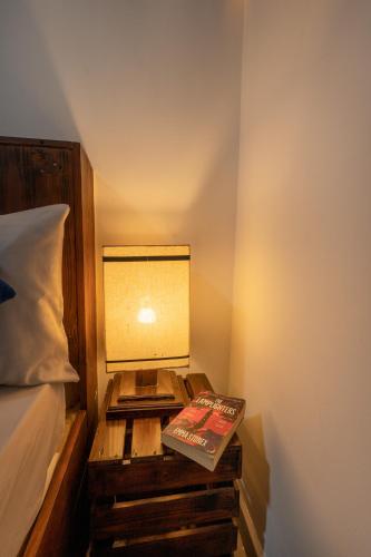 a bedside table with a lamp and a book on it at Mandavilla Airport Transit Hotel in Katunayake