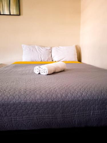 a bed with two rolled up towels on it at Yellow breeze loft, Paseo Durango in Durango