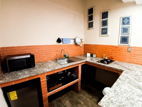 a kitchen with a sink and a microwave at Yellow breeze loft, Paseo Durango in Durango