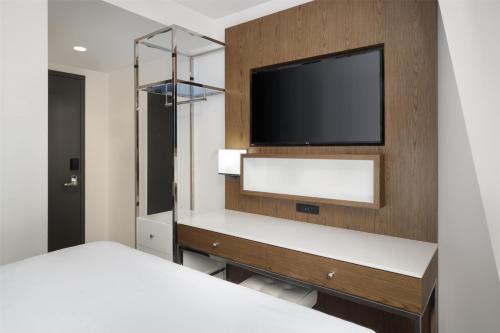 a bedroom with a bed and a tv on a wall at Best Western Premier Empire State Hotel in New York