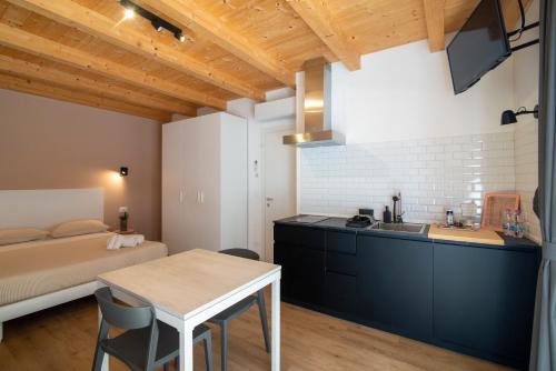 a kitchen and living room with a bed and a table at ALOE Comfort Rooms in Pescara
