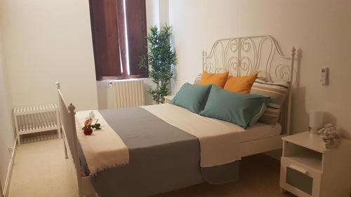 a bedroom with a bed with orange and blue pillows at B&b Oltre l'Arco in Molfetta