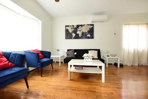 a living room with a blue couch and a table at Great! Private NYC Room in Sunnyside in Haberman