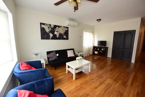 a living room with a blue couch and a table at Great! Private NYC Room in Sunnyside in Haberman