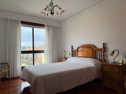 a bedroom with a bed and a large window at OriXe e Kalma in Celanova