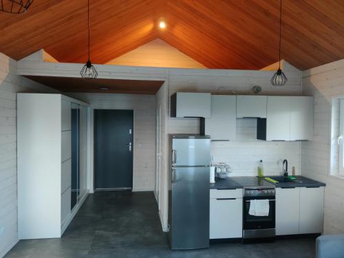 a kitchen with white appliances and a wooden ceiling at Altana Kasztelana - Domek Letniskowy z tarasem i jacuzzi nad Dunajcem Velo in Wojnicz