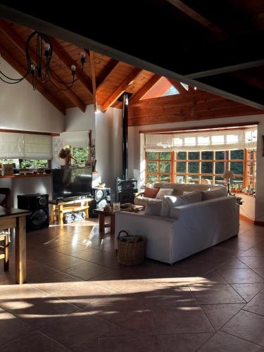 a living room with a white couch and a table at Warm house in Bariloche - Breakfast - Barrio Belgrano in San Carlos de Bariloche
