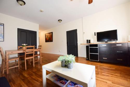 a living room with a table and a tv at Great! Private NYC Room in Sunnyside in Haberman