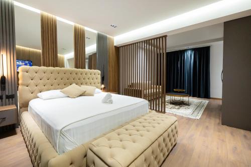 a large bedroom with a large bed and a bench at Hotel Tragjasi in Orikum